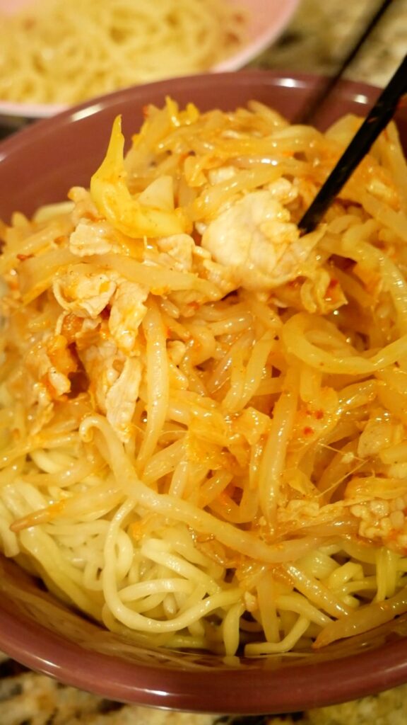麺の上にもやしと豚肉をのせる