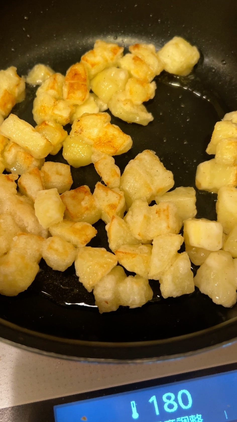 フライパンで揚げ焼きされているじゃがいも