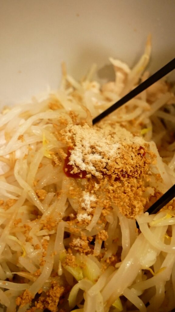 もやしに調味料を加える