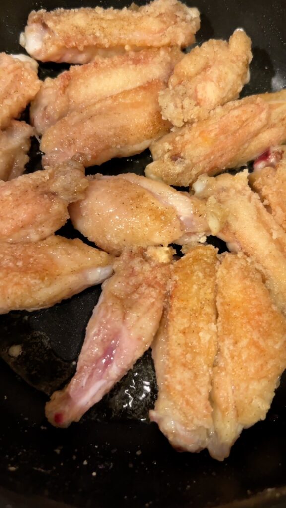 フライパンで手羽中をカリッと揚げ焼きする様子