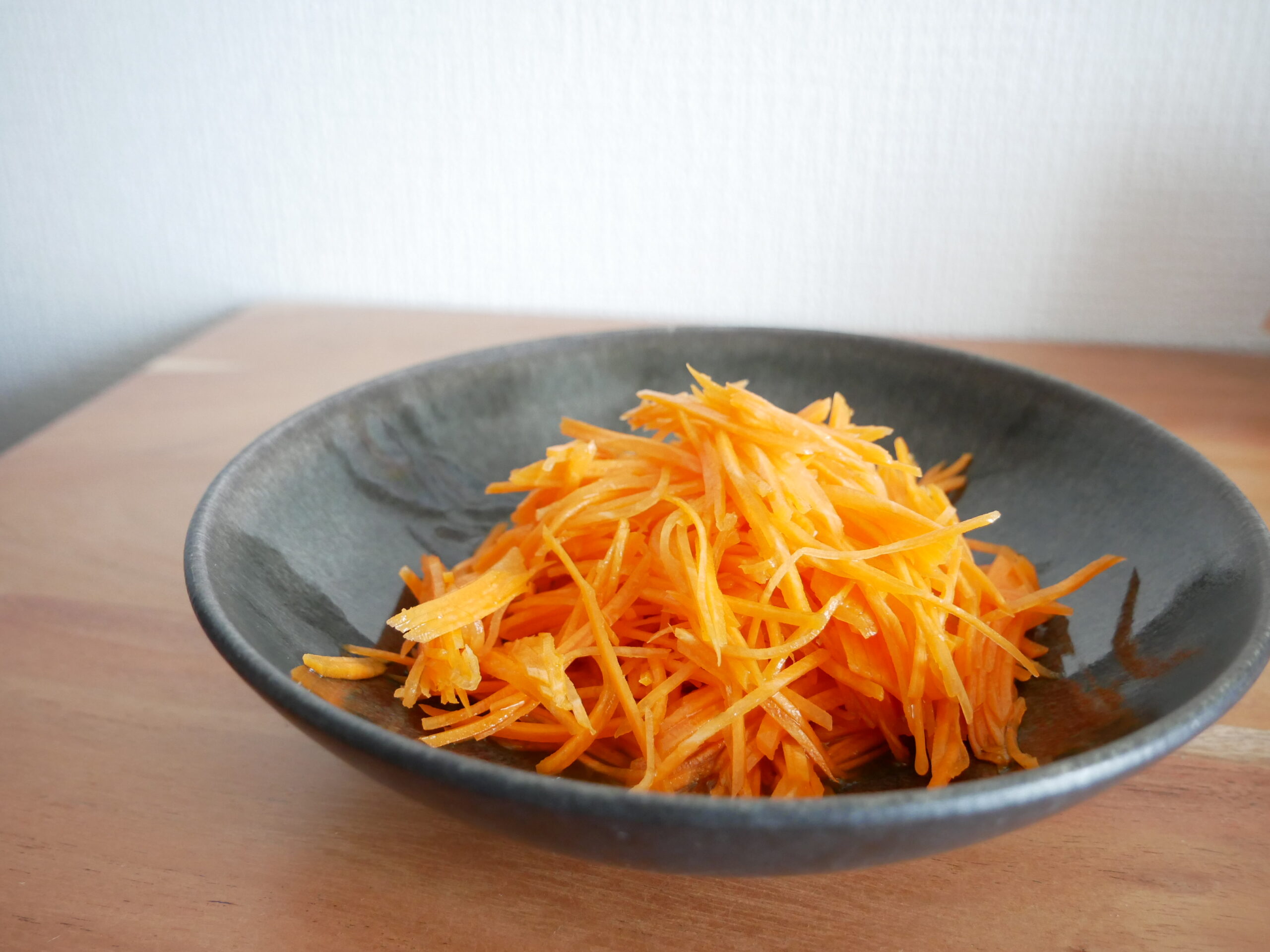 Japanese-style carrot salad in a dark bowl