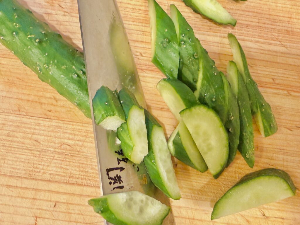 きゅうりを半分に切ってから斜めにカットしている工程