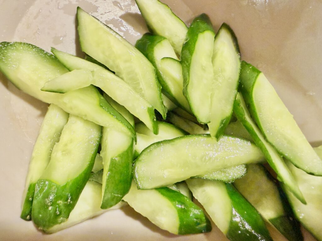 塩を振ったきゅうりから水分を出して絞っている工程