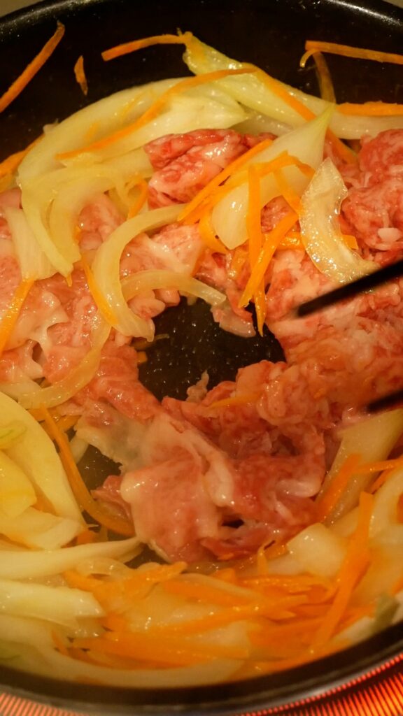 玉ねぎとにんじん、牛肉を炒めているところ