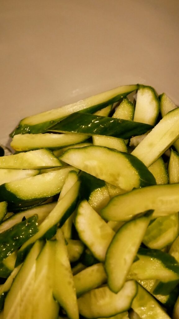 apanese chicken and cucumber salad served in a black bowl