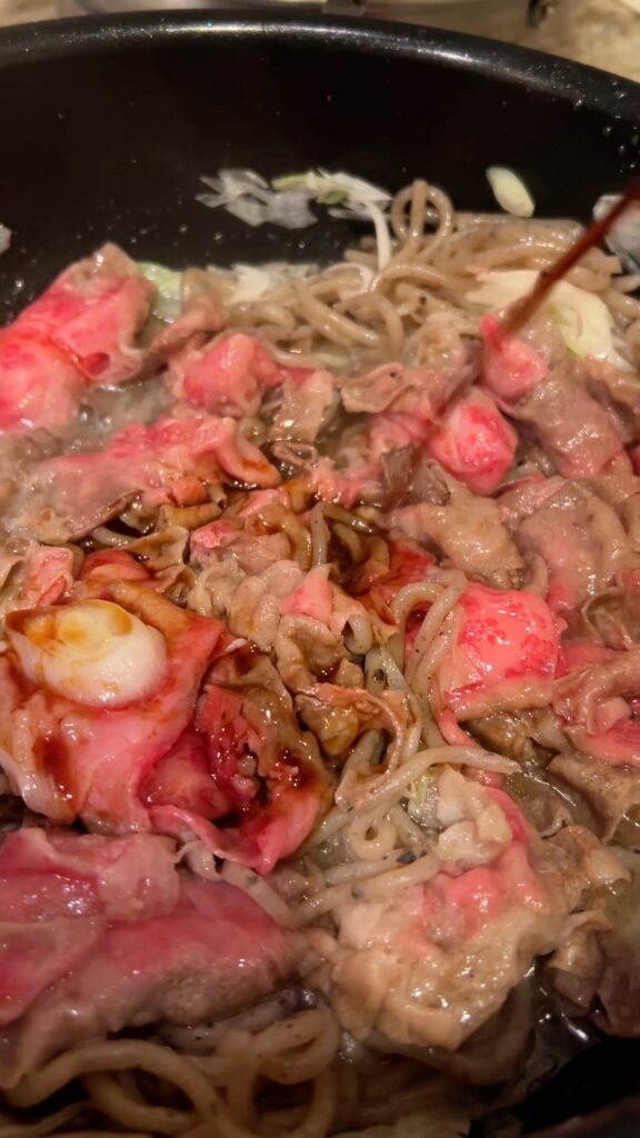 Pouring soy-based sauce over beef and shirataki noodles
