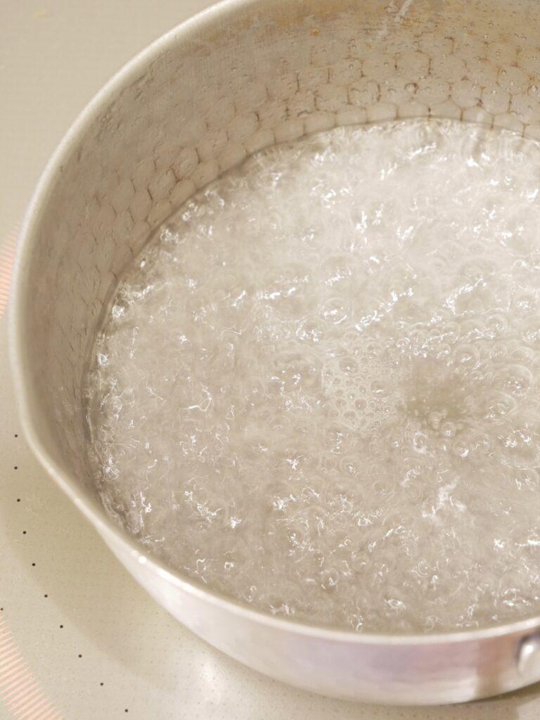 鍋で砂糖と水を加熱して沸騰している様子