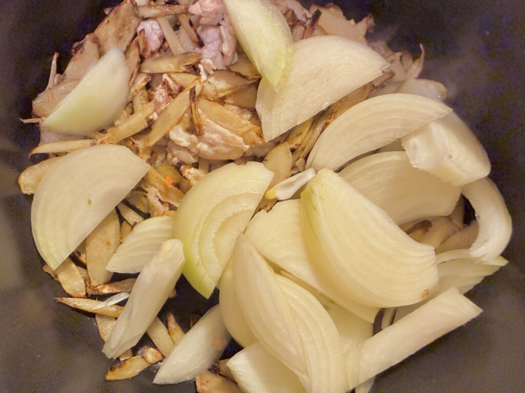 豚汁の調理工程|炒めた豚肉に玉ねぎを加える様子