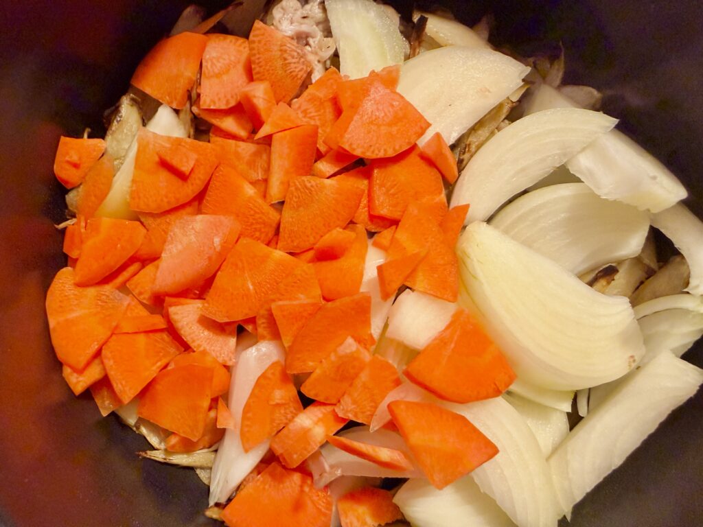 豚汁ににんじんを加えて炒めている工程