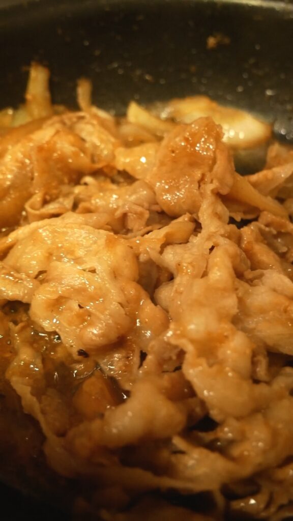 甘辛だれで炒め煮にされる豚肉のしょうが焼き
