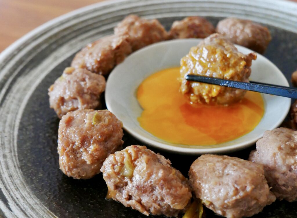 卵黄だれにつけて食べる豚つくねの完成写真。ジューシーでお弁当にも作り置きにも使えるつくね。