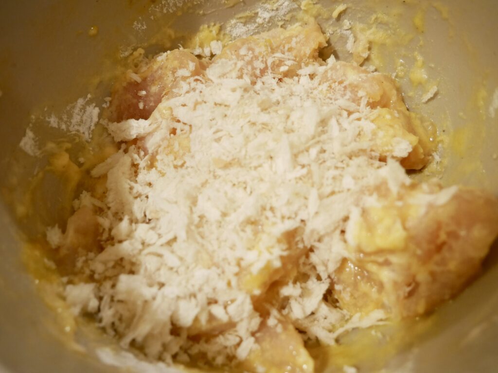 ボウルに入れたささみに塩こしょうで下味をつける様子