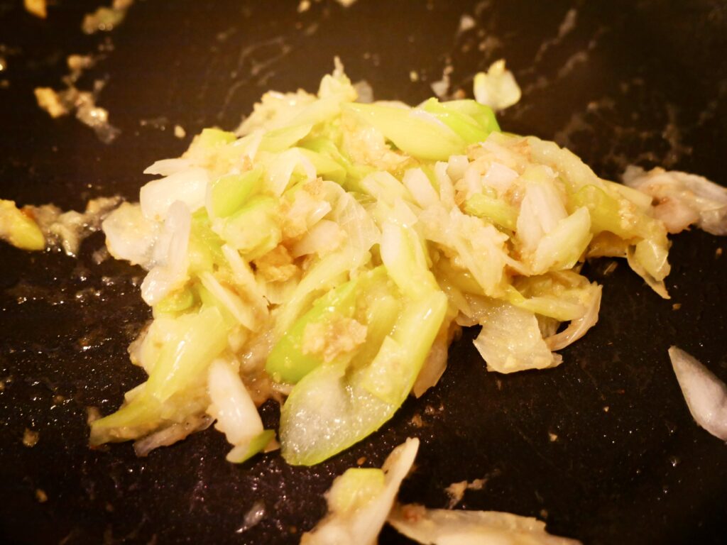 ネギと生姜を豆板醤と一緒に炒めて香りを出している工程写真