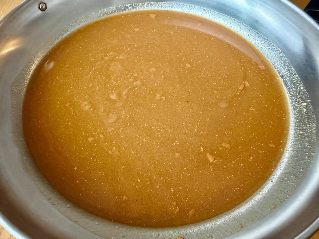 よしもとカレー鍋つゆを温めた鍋の中身。スパイスが香るカレー色のスープが広がっている。