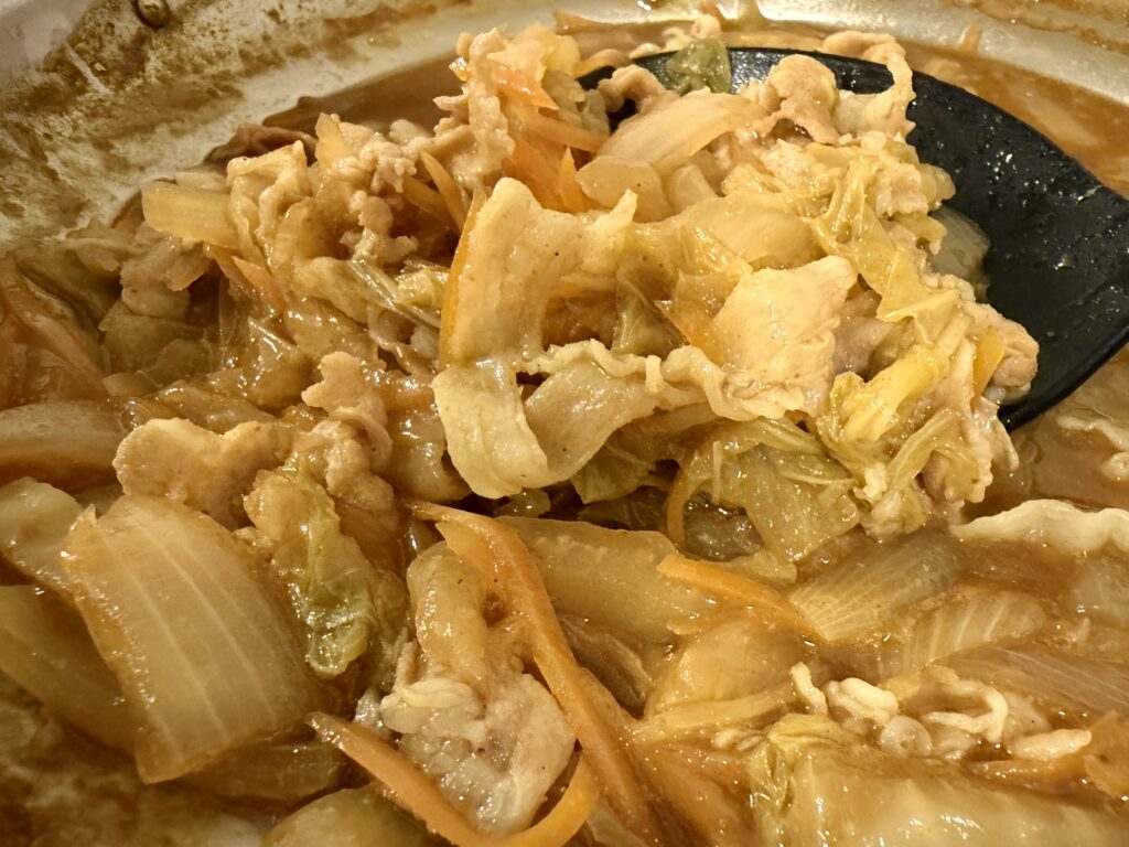 よしもとカレー鍋つゆで作ったカレー鍋。豚肉やキャベツ、にんじん、じゃがいもが煮込まれている。