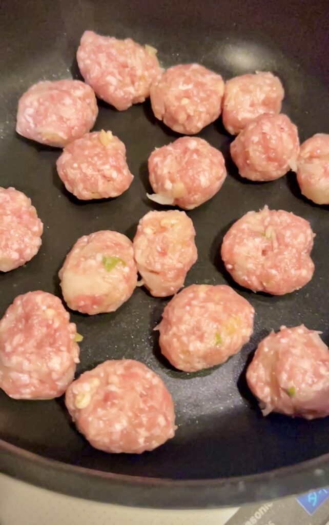 一口サイズに丸めたつくねのタネをフライパンに並べたところ。