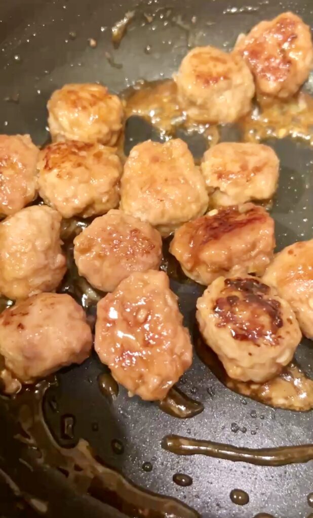 甘辛だれを絡めて照りが出てきたつくねの様子。