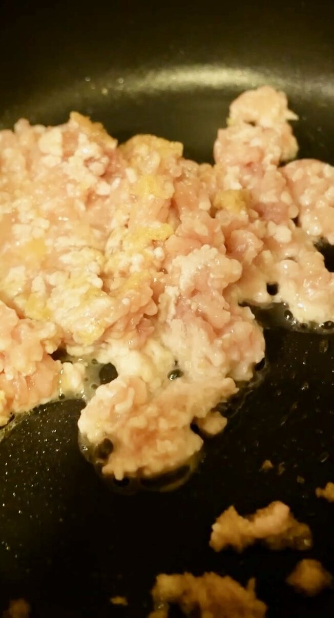 鶏ひき肉をフライパンで炒め始めた途中工程の写真。