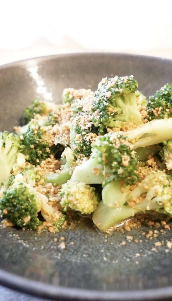Japanese sesame broccoli served in a bowl, topped with ground sesame