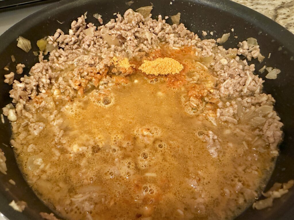 タコライスの素と水を加えて煮込んでいるタコミート