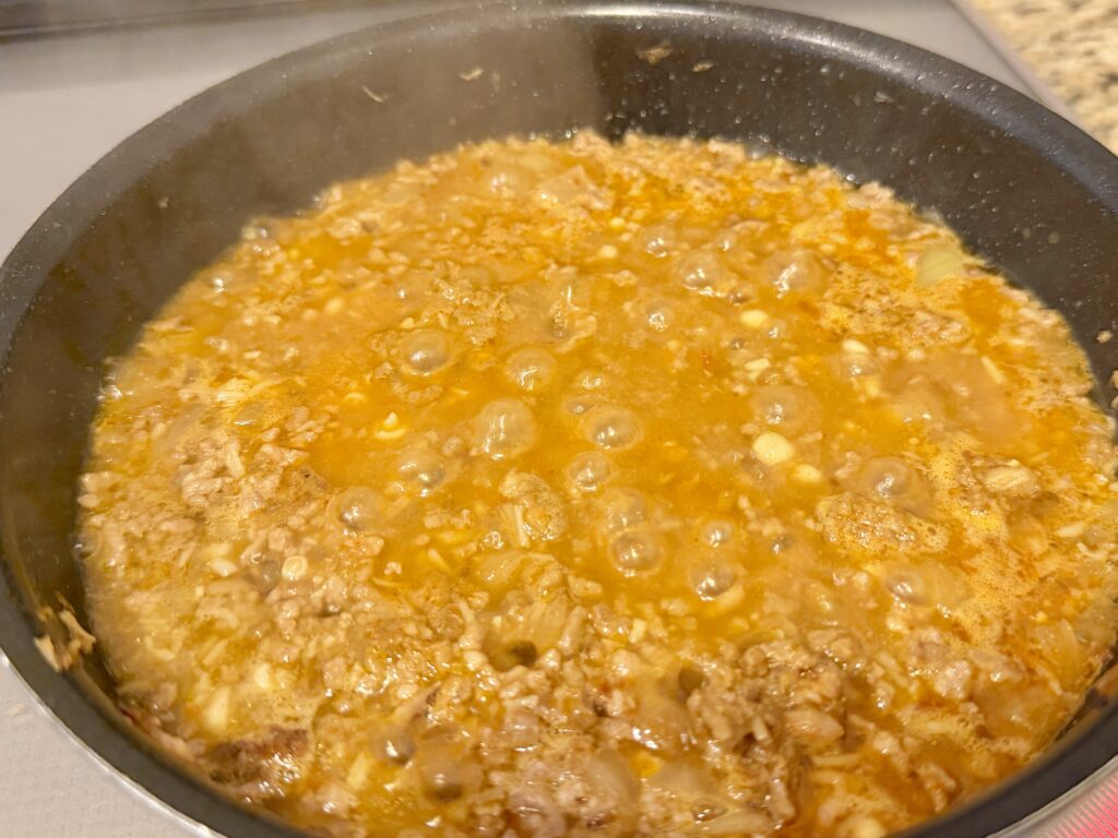 タコライスの具材が煮込み途中で全体に馴染み始めた様子