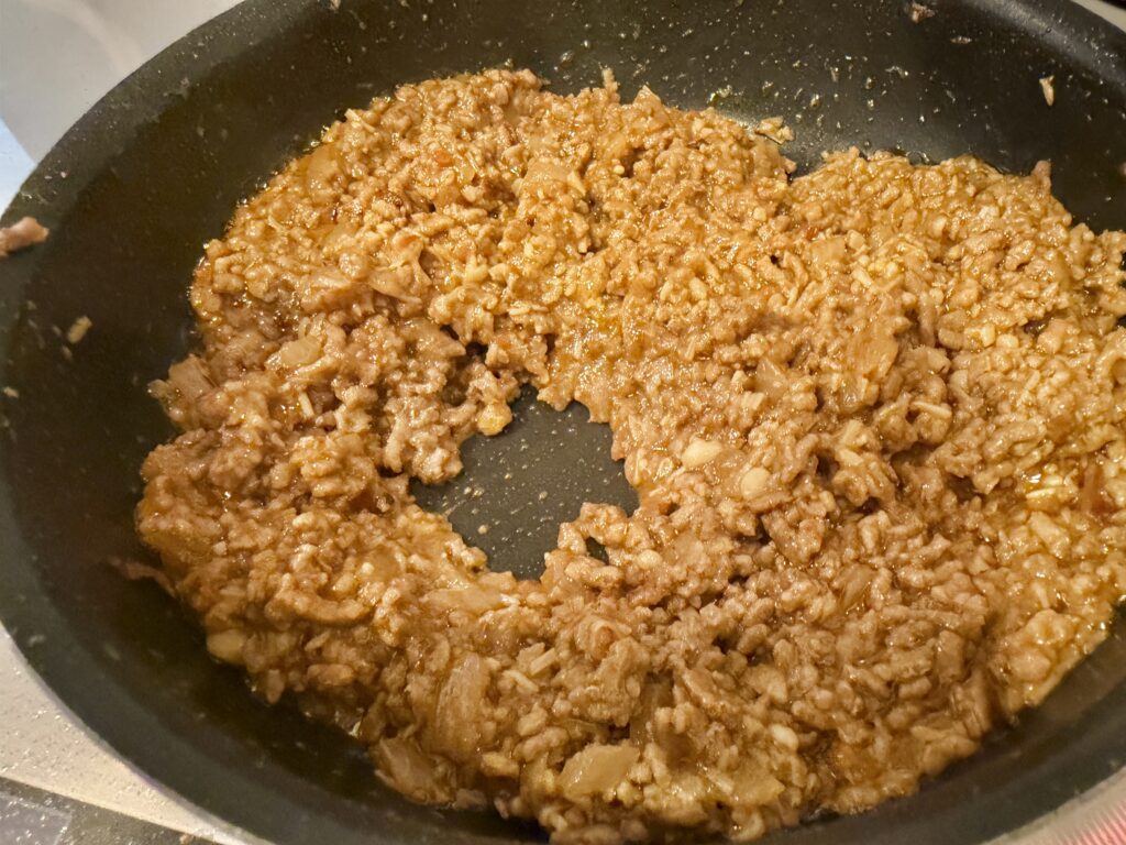 タコライスのミートが調理完了直前の濃厚な状態に煮詰まった様子