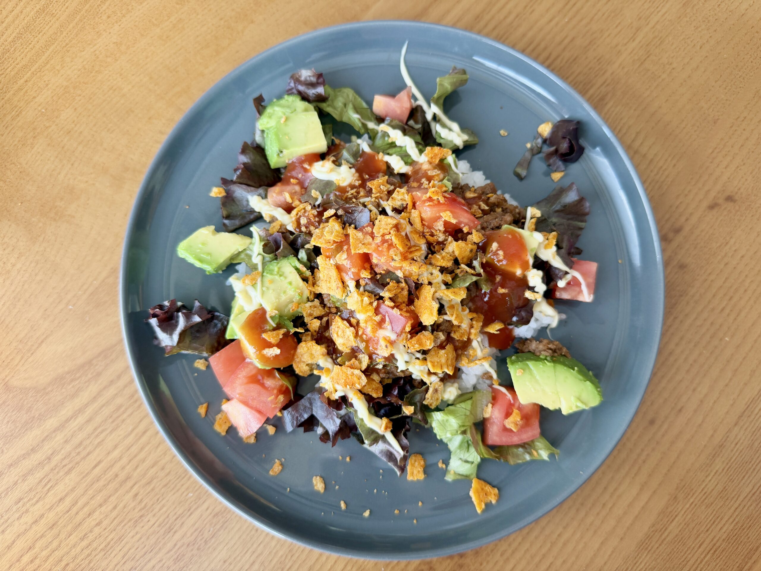 アボカドとトマトをトッピングした本格タコライスの盛り付け