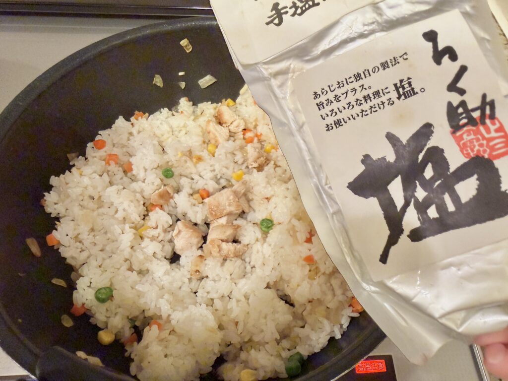 三色ピラフに焼いた鶏むね肉を加え、らく助の塩で味付けしている工程