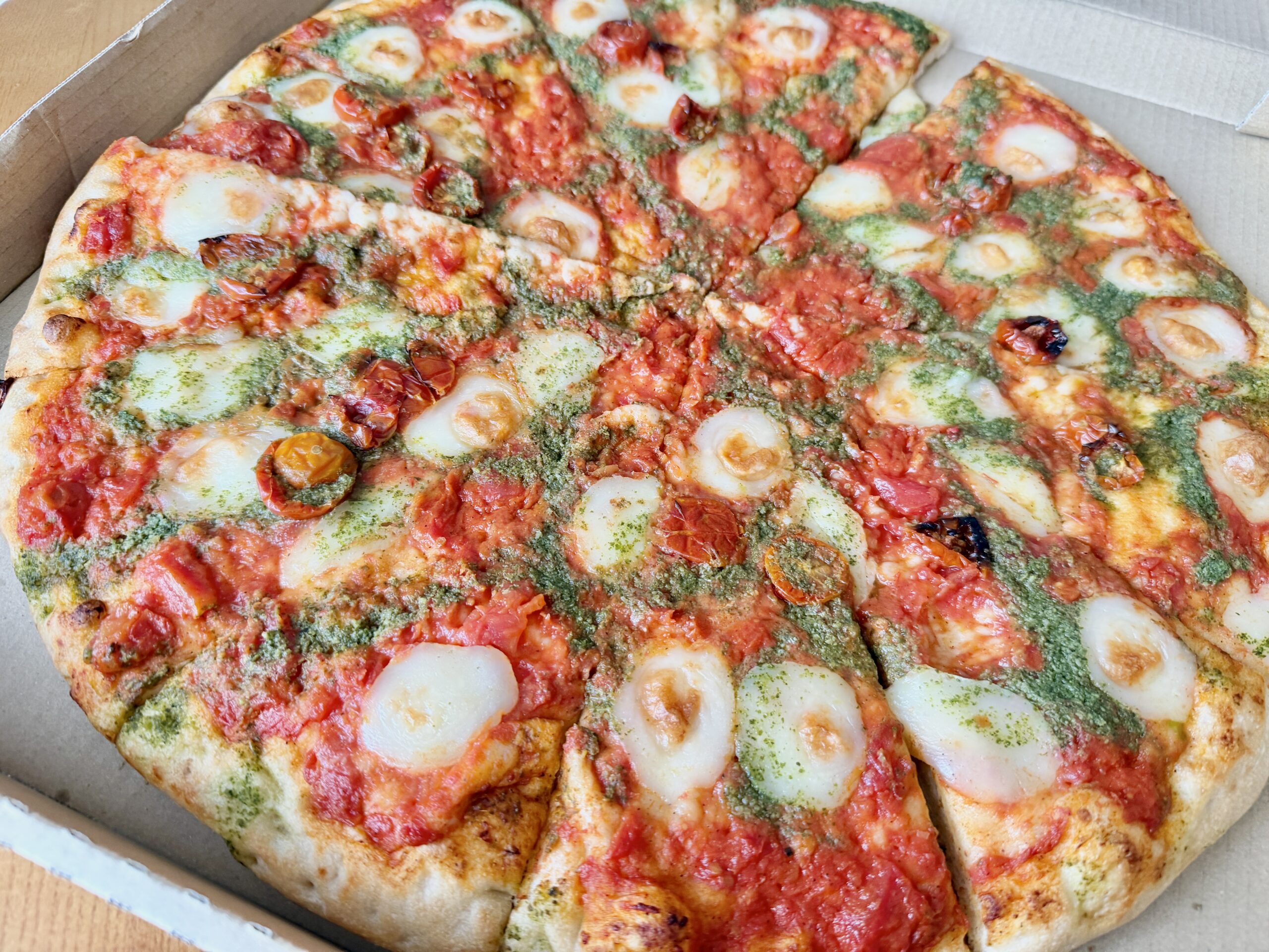 コストコのフードコートで購入したマルゲリータピザの全体写真。大きめのサイズでトマトとモッツァレラが並ぶ人気メニュー。