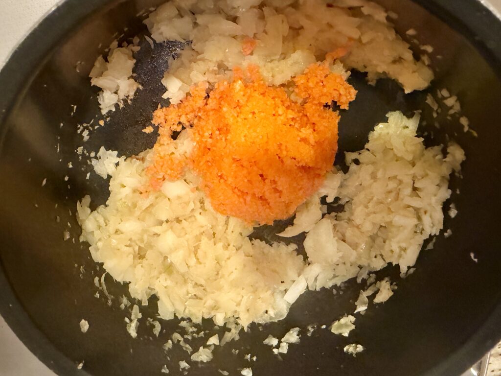 ミートソースにすりおろしたにんじんを加える工程