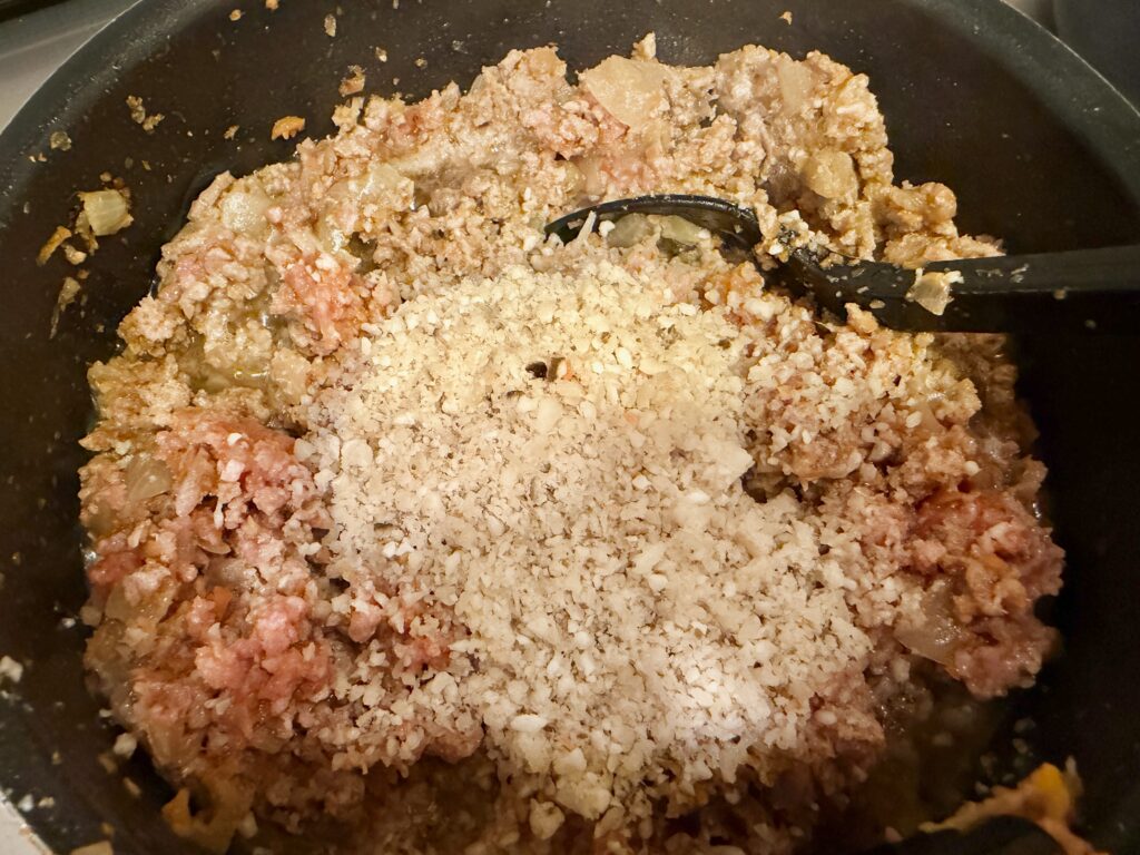 ミートソースにみじん切りのえのきを加える工程