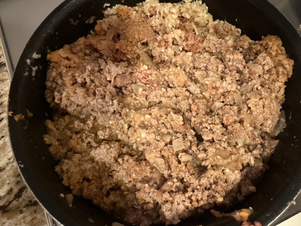 えのきを加えたミートソースの具材を炒めている様子