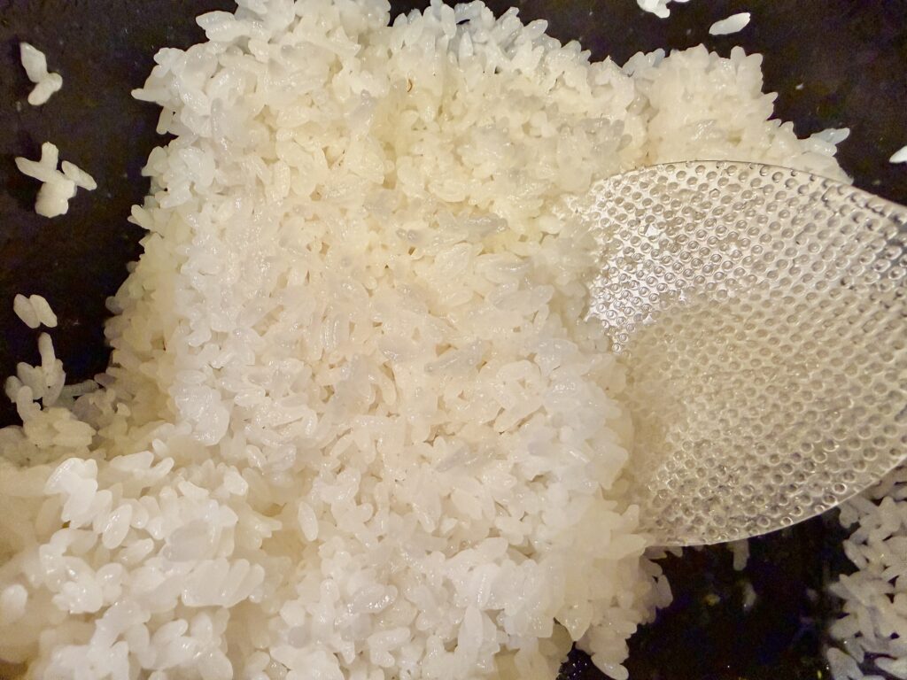 マーナの立ちしゃもじで炊き立てご飯をよそう様子｜くっつきにくい凹凸加工が便利