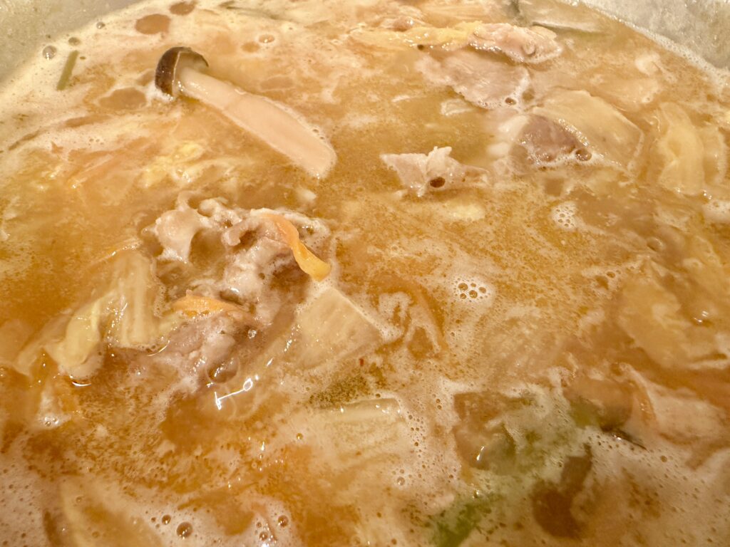 具材の旨みが溶け出したけやき味噌鍋の煮込み中