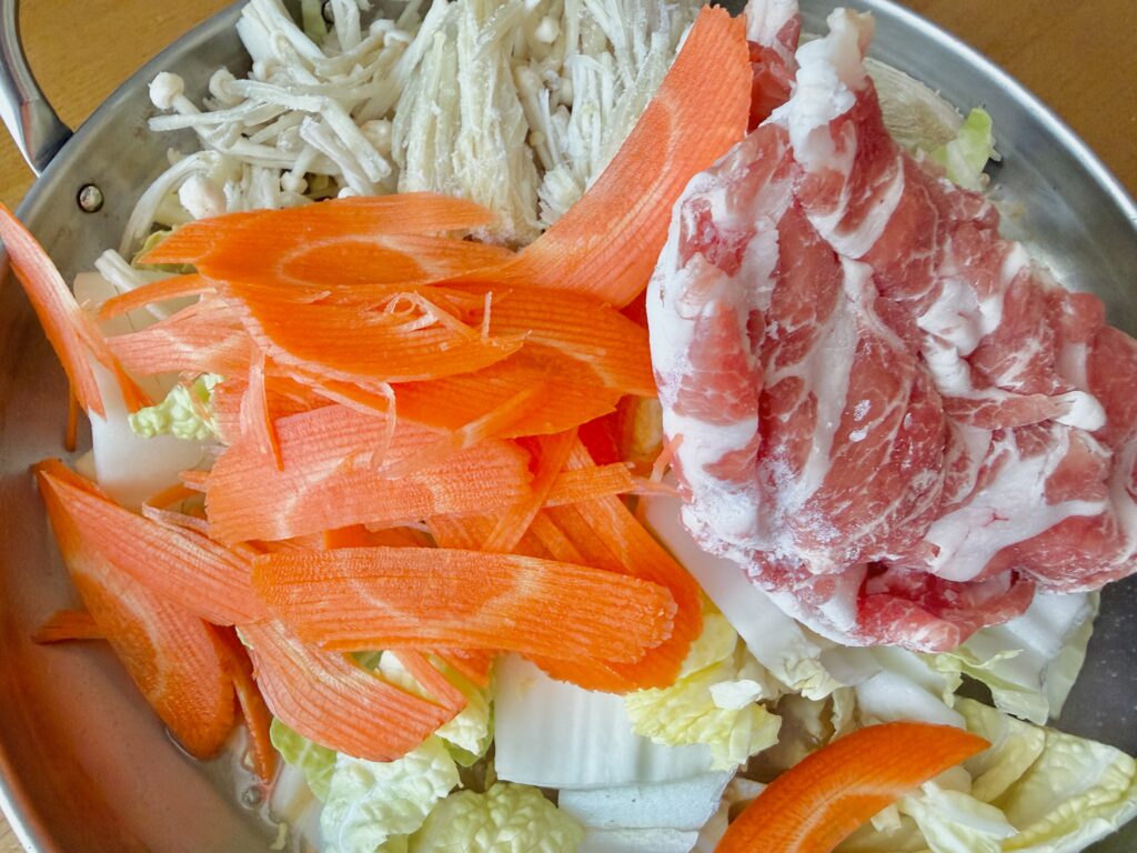 ミツカン 濃厚豚骨魚介鍋つゆ 豚肉と野菜を入れた鍋の具材