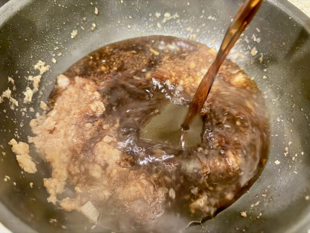 玉ねぎペーストに調味液を加えている様子