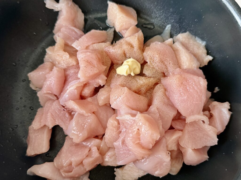 鶏胸肉に塩こしょうとマヨネーズを加えて下味をつけている様子