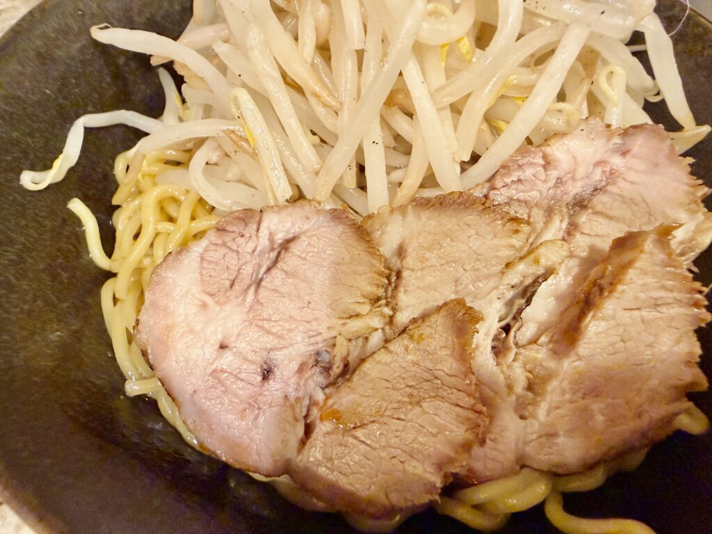 油そばにチャーシューをのせる