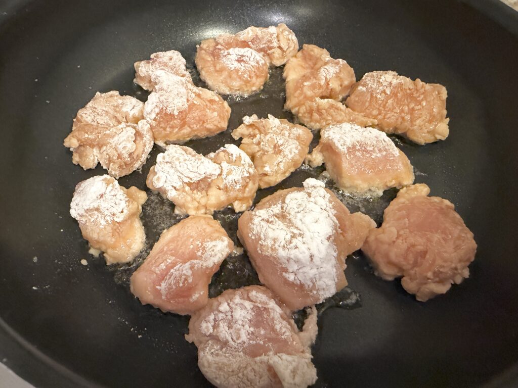 フライパンで鶏胸肉の唐揚げを揚げ焼きしている様子