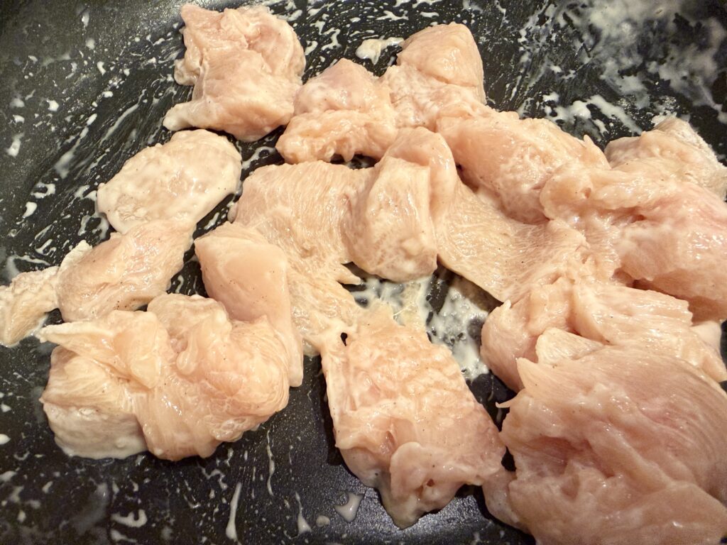 フライパンの中で鶏むね肉に下味を揉み込んだ状態