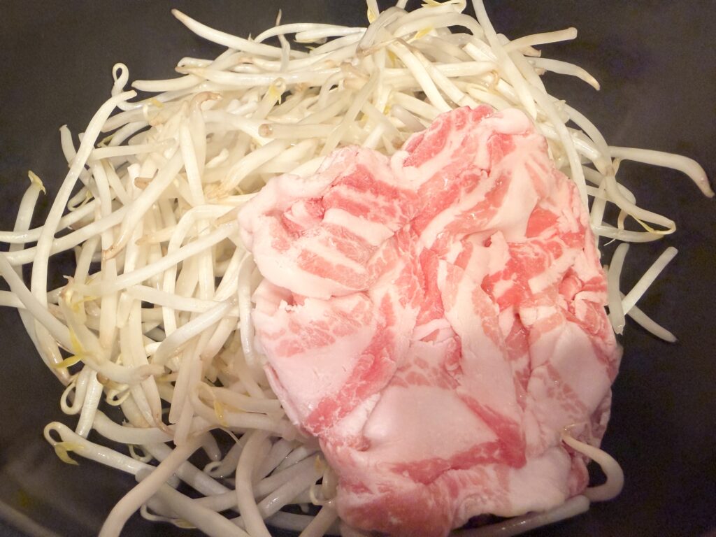 もやしと豚バラ肉をフライパンに入れた状態