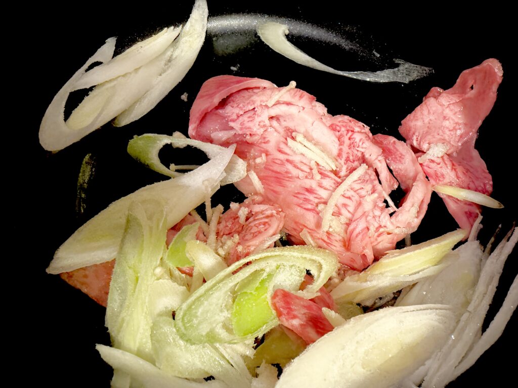 韓国スープ用の牛肉と長ねぎ、生姜を炒める様子
