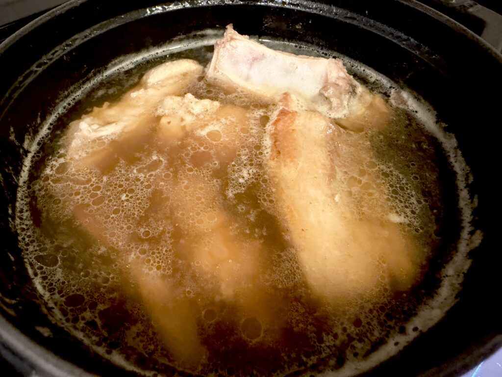 調味料を加えてスペアリブを煮込む様子