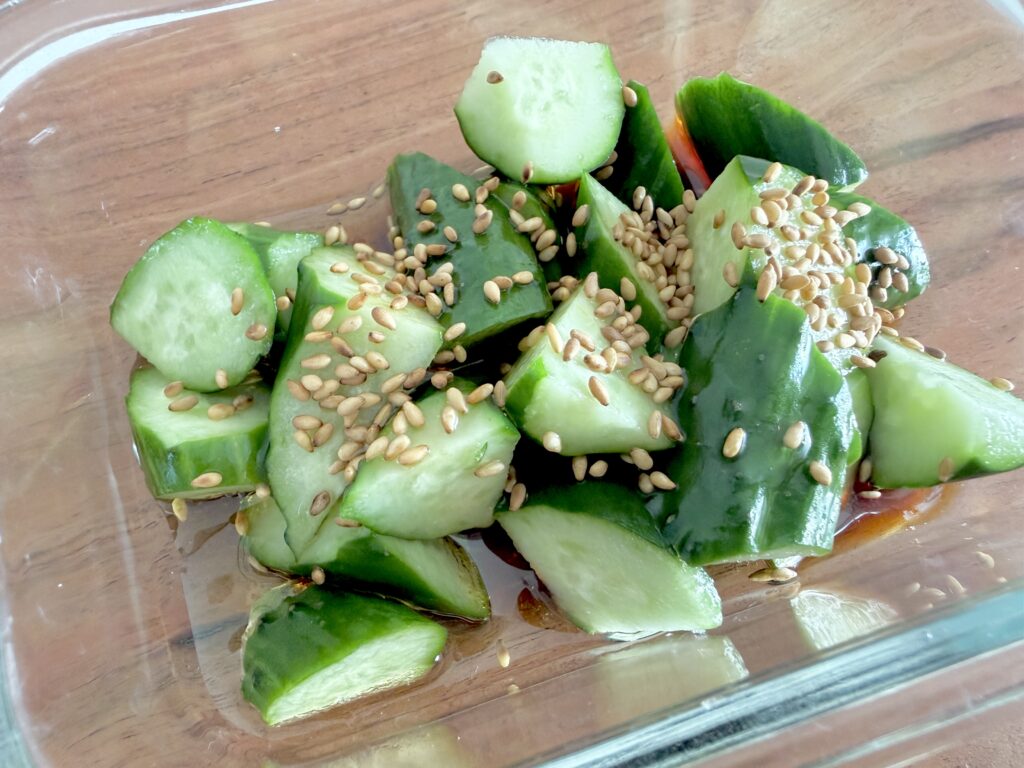 きゅうりに醤油、ごま油、酢、ごまを加えて漬け込む様子