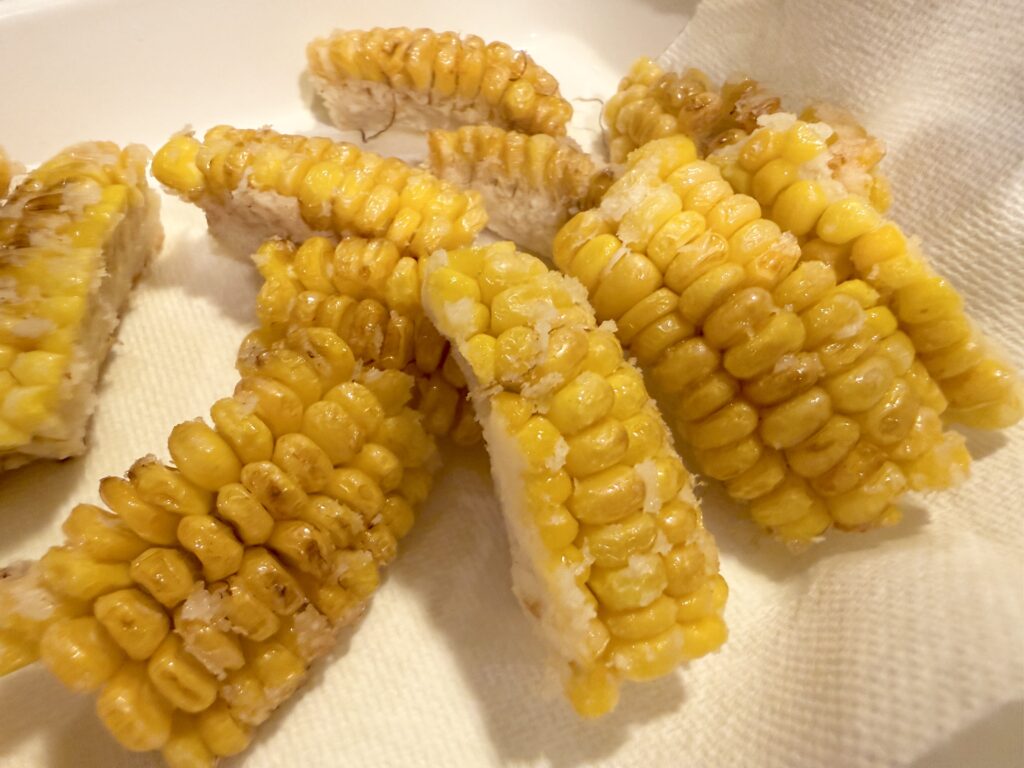 揚げたとうもろこしの油を切る様子