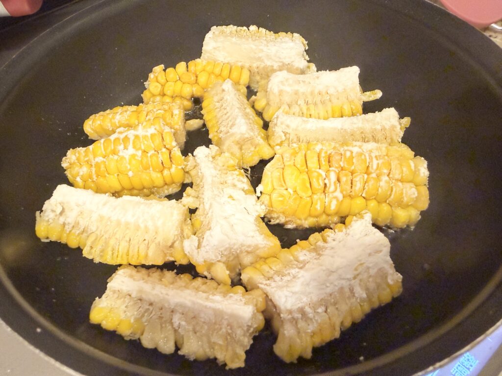 片栗粉をまぶしたとうもろこしをフライパンで揚げる様子