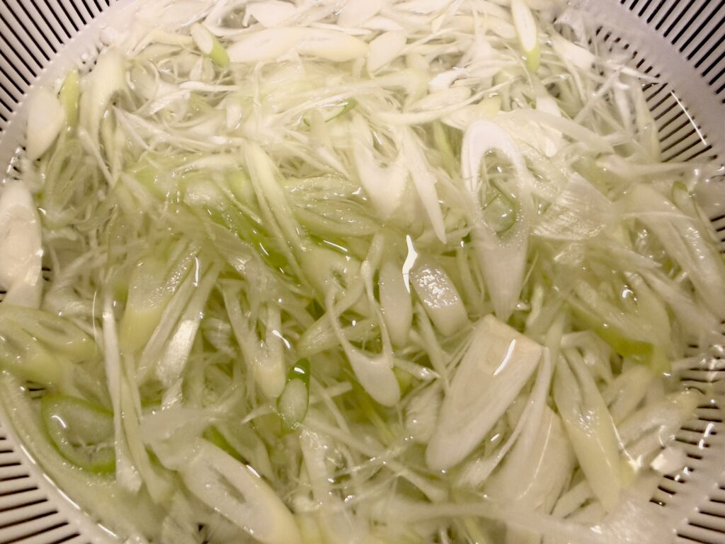 薄切りにした長ネギを水にさらす様子